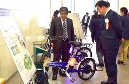 電動2輪モビリティ「Kushi」と給電システムの説明を聞く清水市長