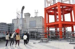 ビル上の巨大な電波塔を見上げる
